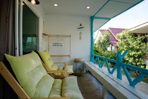 a porch with a couch and chairs on a balcony at Dream Villa Beachside Sunset in Ban Bang Po