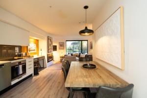 a kitchen and living room with a table and chairs at Hygge Garden Apartment with Private Sauna in Queenstown