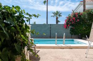 a swimming pool with two surfboards in front of a house at Marvista - Bright Apt w Seaview, Pool in Sant Pere de Ribes