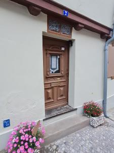 a wooden door on the side of a building with flowers at Ferienhaus Schatzliebe in Quedlinburg