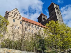 an old building with two towers and trees at Ferienhaus Schatzliebe in Quedlinburg