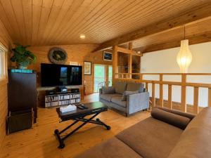 a living room with a couch and a tv at Best View in Nakafurano