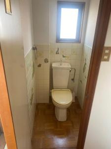 a small bathroom with a toilet and a window at 静佳民宿 in Osaka
