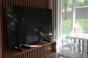 a flat screen tv sitting on a stand next to a window at Maritsch I Apartments in Naturno