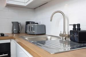 a kitchen counter with a sink and a sink at The Loft Apartment in Elland