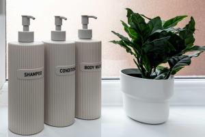 a group of three white gas cylinders next to a plant at The Loft Apartment in Elland