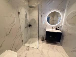 a bathroom with a shower and a sink and a mirror at Gamlebyen Hotell - Fredrikstad in Fredrikstad +33 photos