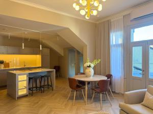 a kitchen and living room with a table and chairs at Gamlebyen Hotell - Fredrikstad in Fredrikstad