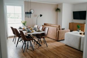a living room with a table and chairs and a couch at Bei Plön mit Seeblick und großem Balkon in Dersau
