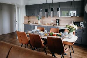 a kitchen with a dining room table and chairs at Bei Plön mit Seeblick und großem Balkon in Dersau +30 photos