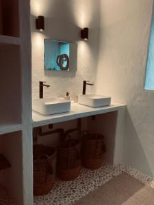 a bathroom with two sinks and two baskets at Chateau de Cours in Sénezergues