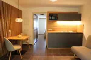a kitchen with a sink and a table with chairs at Maritsch I Apartments in Naturno