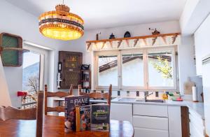 a kitchen with a table and a sink and a window at Lugano Hills View & Parking in Bigorio