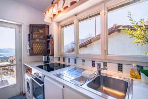a kitchen with a sink and two windows at Lugano Hills View & Parking in Bigorio
