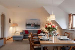 a living room with a table with flowers on it at Haus Wattblick OG in Braderup