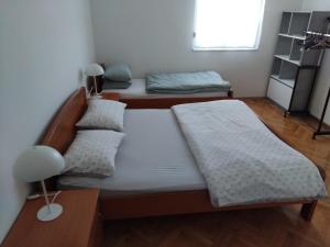 a bedroom with two beds and a lamp in it at Apartman Baška Voda in Baška Voda