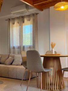 a living room with a couch and a table and chairs at La Pietra Maisonettes in Neokhórion