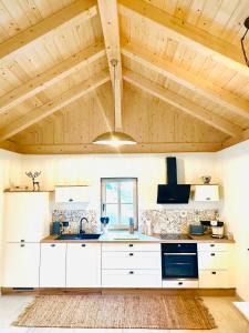 a kitchen with white cabinets and a wooden ceiling at Ferienhaus Steinschlössl in Mühldorf