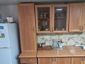 a kitchen with wooden cabinets and a white refrigerator at Hotel kazbegi1 in Ach'khoti