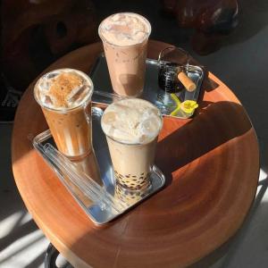 a tray with four different coffee drinks on a table at 75 Staytion in Bien Hoa