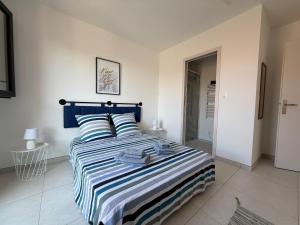 a bedroom with a blue and white bed with towels on it at Villa ROC in Bandol
