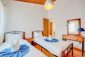 a bedroom with two beds and a desk and a window at Salt & Sun Retreat in Perivolia