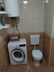 a bathroom with a washing machine and a toilet at Apartman Baška Voda in Baška Voda +30 photos