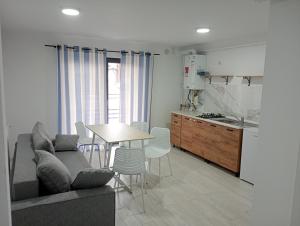 a living room with a couch and a table and a kitchen at Deluxe apartament Vatra Dornei in Vatra Dornei