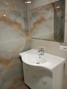 a bathroom with a white sink and a mirror at Deluxe apartament Vatra Dornei in Vatra Dornei +7 photos