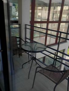 a table and chairs on a balcony with a window at Deluxe apartament Vatra Dornei in Vatra Dornei