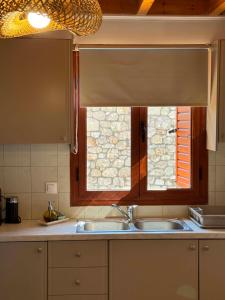 a kitchen with a sink and a window at La Pietra Maisonettes in Neokhórion