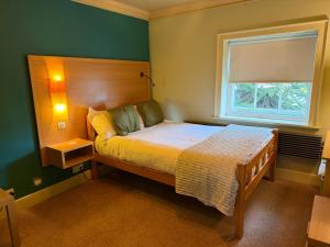 ein Schlafzimmer mit einem großen Bett und einem Fenster in der Unterkunft Old Orleton Inn - Telford in Telford