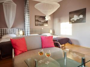 切霍奇內克的住宿－潘斯約納特波德傑米歐拉酒店，客厅配有沙发和两杯葡萄酒