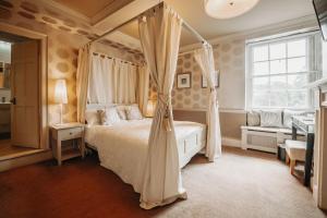 ein Schlafzimmer mit Himmelbett und Fenster in der Unterkunft Old Orleton Inn - Telford in Telford