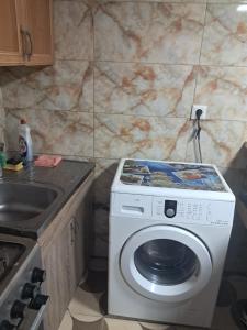 a kitchen with a washing machine and a sink at Hotel kazbegi1 in Ach'khoti