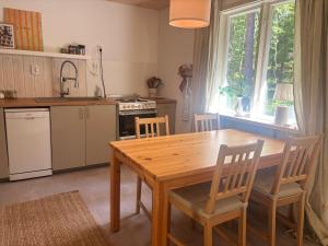 a kitchen with a wooden table and chairs in it at Stuga Rödhake in Annerstad
