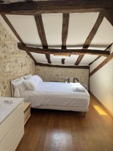 a bedroom with a white bed and wooden floors at Fontaine de Champagne in Champagne-et-Fontaine +19 photos