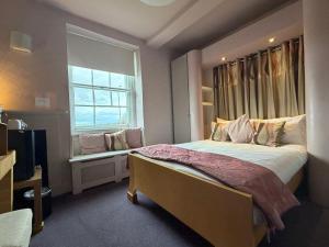 ein Schlafzimmer mit einem großen Bett und einem Fenster in der Unterkunft Old Orleton Inn - Telford in Telford