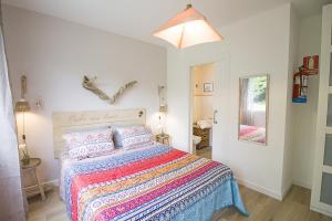 a bedroom with a bed with a colorful bedspread at La Casa del Petirrojo de Ribamontan al Mar con Surf y Tranquilidad in Castanedo