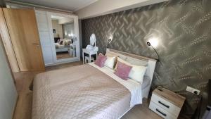 a bedroom with a large bed with pink pillows at Riella Home in Szombathely +4 photos