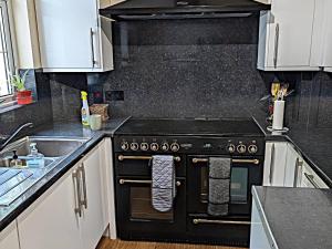 a kitchen with a stove and a sink at Callart View in Ballachulish
