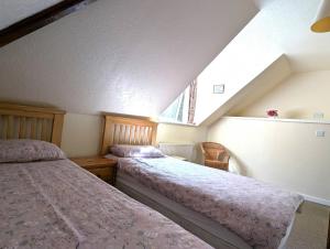 a attic bedroom with two beds and a window at Callart View in Ballachulish