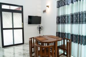 a dining room with a table and chairs and a window at JY Apartments in Negombo