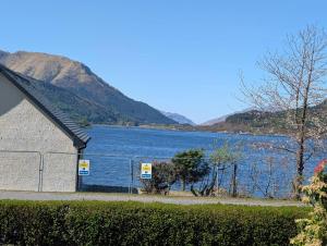 a building next to a large body of water at Callart View in Ballachulish +10 photos