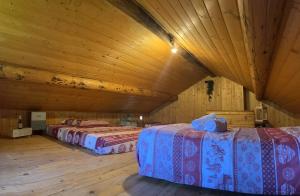 two beds in a room with wooden ceilings at Baita Lodge Valfreda in Falcade