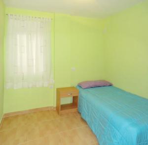 a bedroom with a bed and a table and a window at Apartamento Goya in Málaga