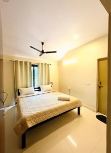 a bedroom with a bed with a ceiling fan at Serenity Villa in Rushikonda