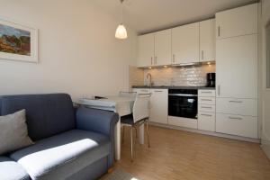 a living room with a couch and a kitchen at Ferienwohnung Filter in Hörnum +3 photos