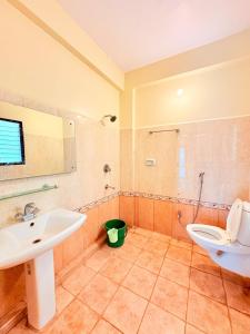 a bathroom with a sink and a toilet at Serenity Villa in Rushikonda +21 photos