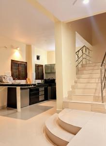 a living room with a staircase and a desk at Serenity Villa in Rushikonda